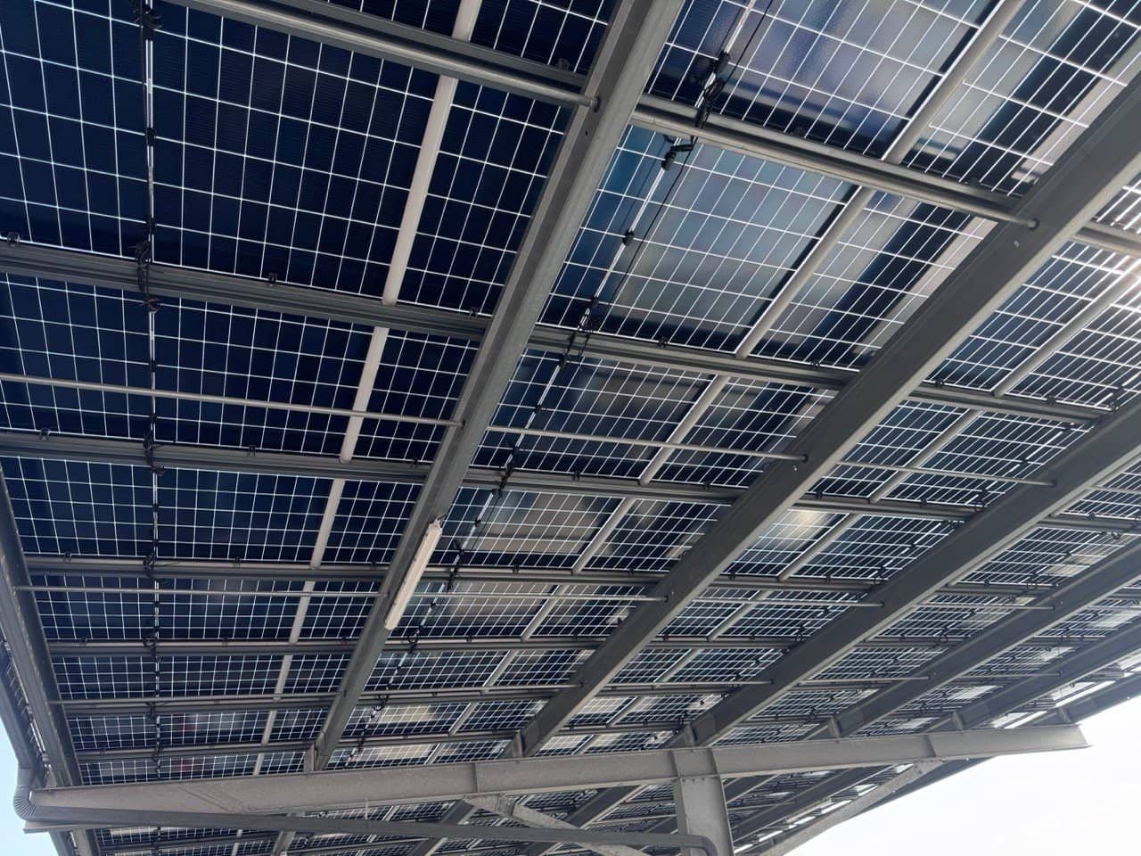 Ombrière photovoltaïque installée sur un parking, conforme à la loi APER