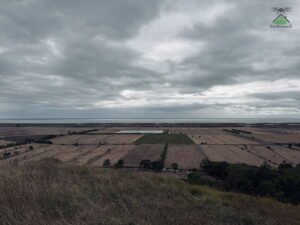 Couverture nuageuse basse et uniforme au-dessus d'une plaine agricole bordée de la Garonne