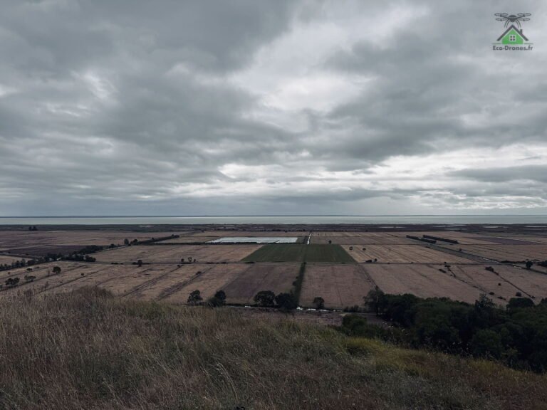 Couverture nuageuse basse et uniforme au-dessus d'une plaine agricole bordée de la Garonne
