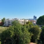 Vue aérienne par drone d'une résidence en copropriété : immeubles à toits-terrasses, balcons, pelouse et parc arboré