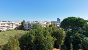 Vue aérienne par drone d'une résidence en copropriété : immeubles à toits-terrasses, balcons, pelouse et parc arboré