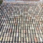 Vue aérienne verticale par drone d'une toiture en tuiles canal mêlant tuiles anciennes et tuiles neuves de remplacement, couverture saine prête pour un hydrofuge
