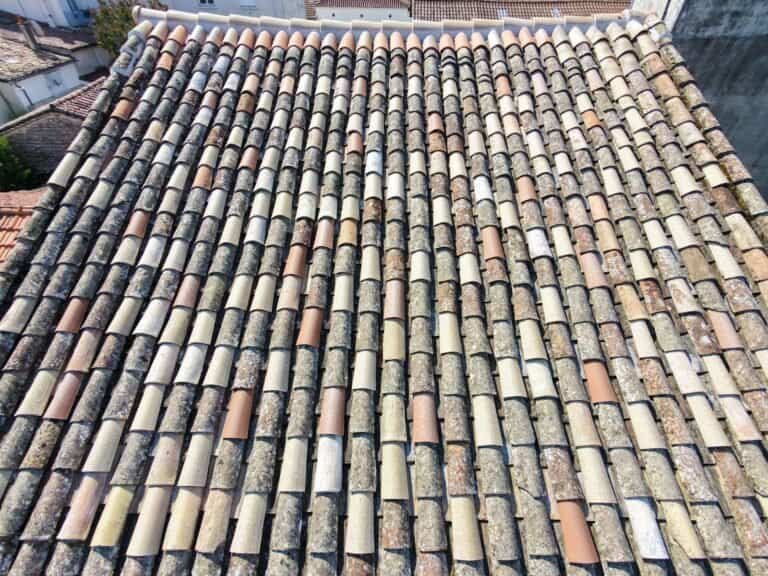 Vue aérienne verticale par drone d'une toiture en tuiles canal mêlant tuiles anciennes et tuiles neuves de remplacement, couverture saine prête pour un hydrofuge